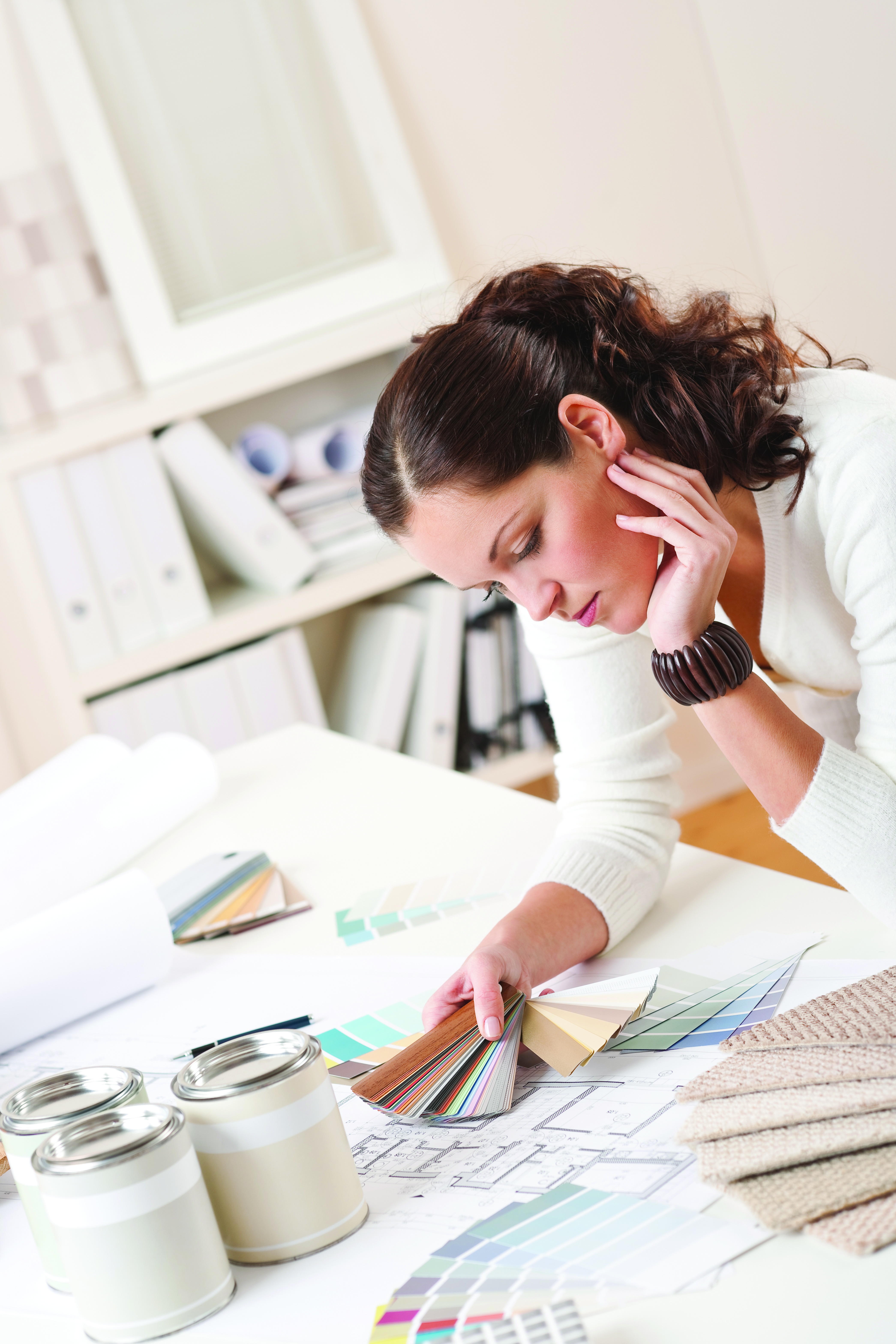 Stock Image - Inteiror Designer evaluating plans at a table